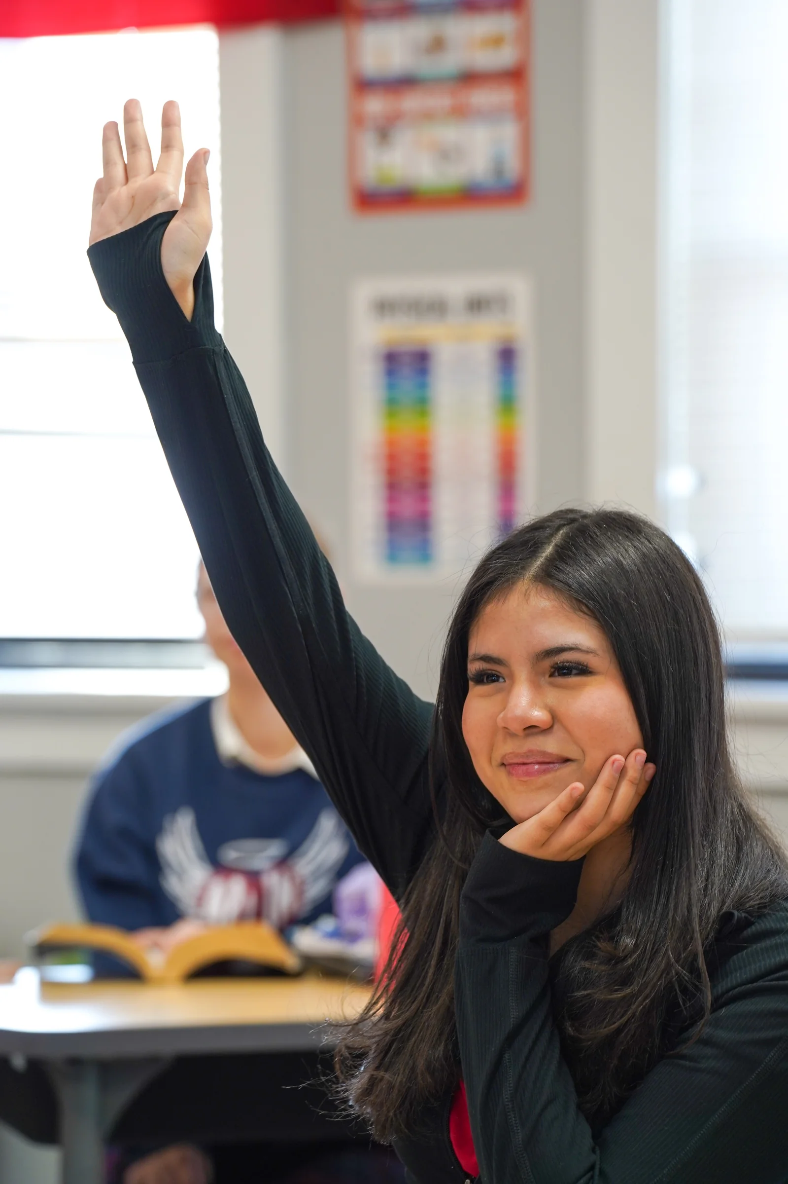 A VCA Scholar with her hand raised