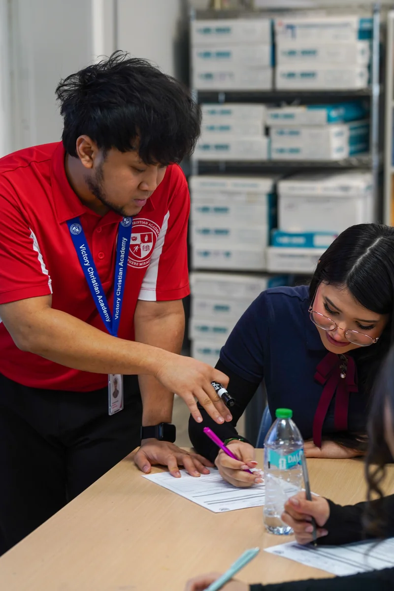 A VCA teacher walking a student through their work